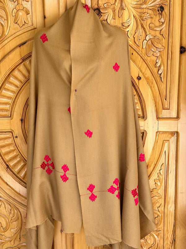 A Swat shawl, crafted from imported Australian wool and perfected by local artisans, hangs gracefully against an ornate wooden door, exuding the elegance of the 72 unique shawls that define true grace.